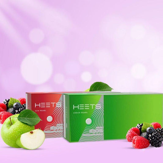 Heets Sun Pearl and Arbor Pearl packs with green apple and berry fruits on pink background.